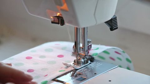 Closeup view of girl sewing on machine
