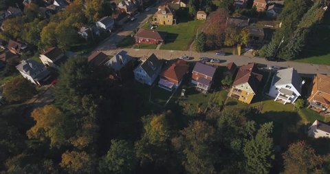 An aerial view above a small Western Pennsylvania town and residential neighborhood on an Autumn evening. Pittsburgh suburb.	 	