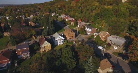 An aerial view above a small Western Pennsylvania town and neighborhood on an Autumn evening. Pittsburgh suburb.  	