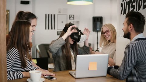 first experience with virtual reality glasses young team supports young beautiful brunette girl in modern startup office