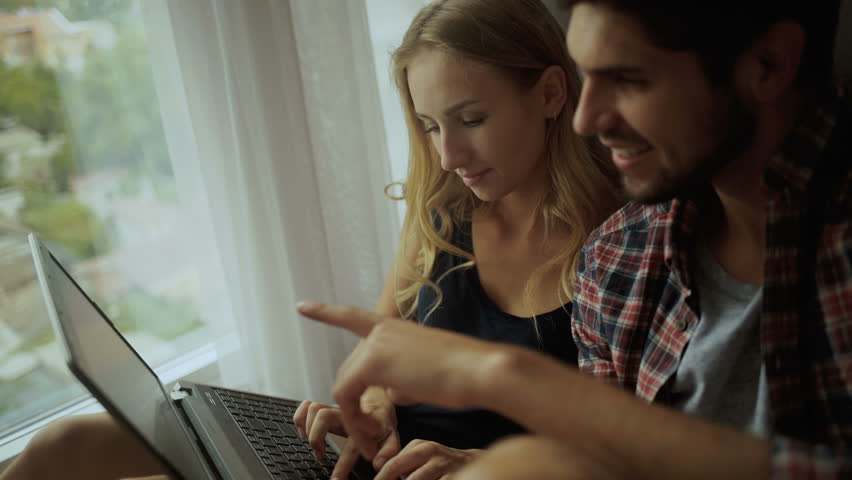 Beautiful couple working on a laptop at home.