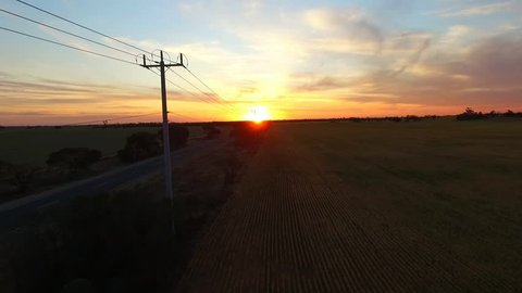 Telegraph Road. Aerial view of outback highway or open road on dusk (sunset) with semi trailer truck,   traveling on rural country high speed motorway. Telegraph poles, power lines & solitude theme. 