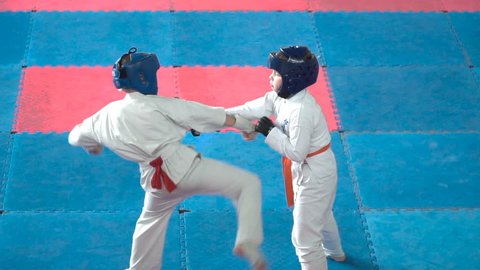 Kids karate competition. Fight a duel of teenagers. Children are protected and strikes the opponent. Young athletes are involved in a fight with courage.