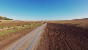 Flight over dirt road through farm fields, aerial video / AERIAL: Flight over dirt road t
