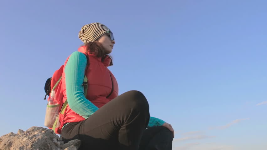 girl looking at sunset in savannah sitting on the rock