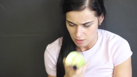 Beautiful girl eating an apple.Wicked girl eats an apple