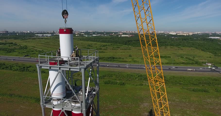 Workers on the top install pipe for gas power plant aerial shot