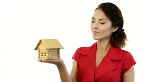Home - new house concept. Woman holding wooden toy model house against isolated white backgroung in studio 