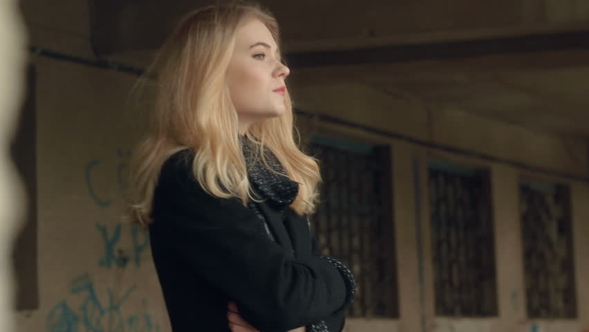 Beautiful blonde young girl fashion look talking with hair waves wind