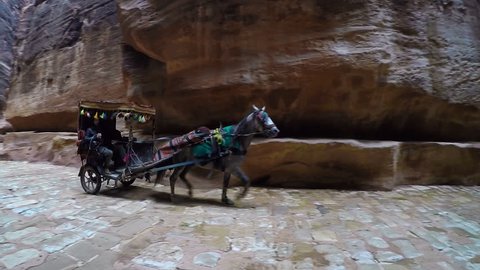 Petra, Jordan - October 26, 2015: Bedouin carriage in Siq passage to Petra city. Bedouin wagon rides in the canyon of Petra. Petra is one the New Seven Wonders of the World. Canyon of city of Petra.