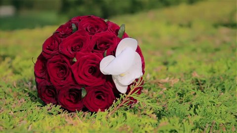 wedding bouquet. wedding bouquet with red roses. wedding bouquet on grass. wedding bouquet with kala flower