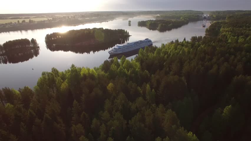 River cruise ship close aerial view. Beautiful Russian nature. Cinematic drone footage from above. Luxury Russian tour from Moscow to St. Petersburg on board. Sunrise. 4k footage.