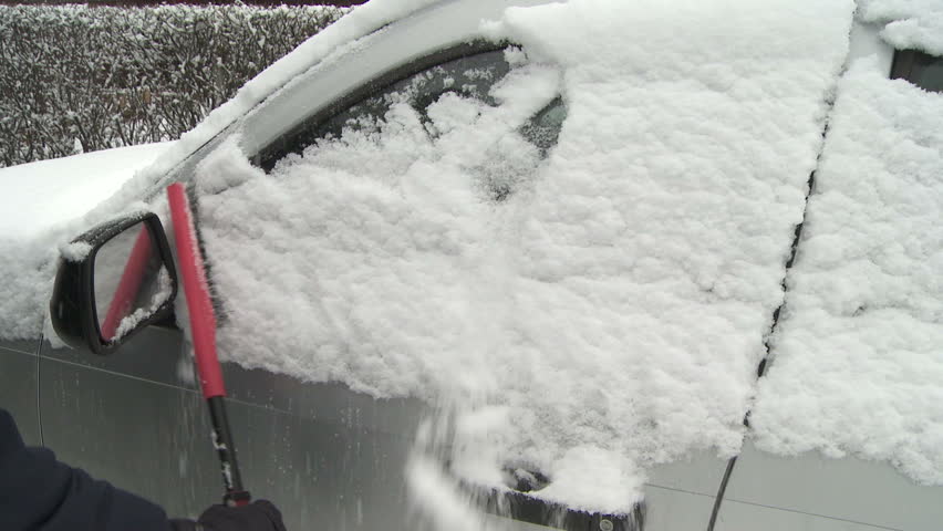 Brushing the snow off a car window