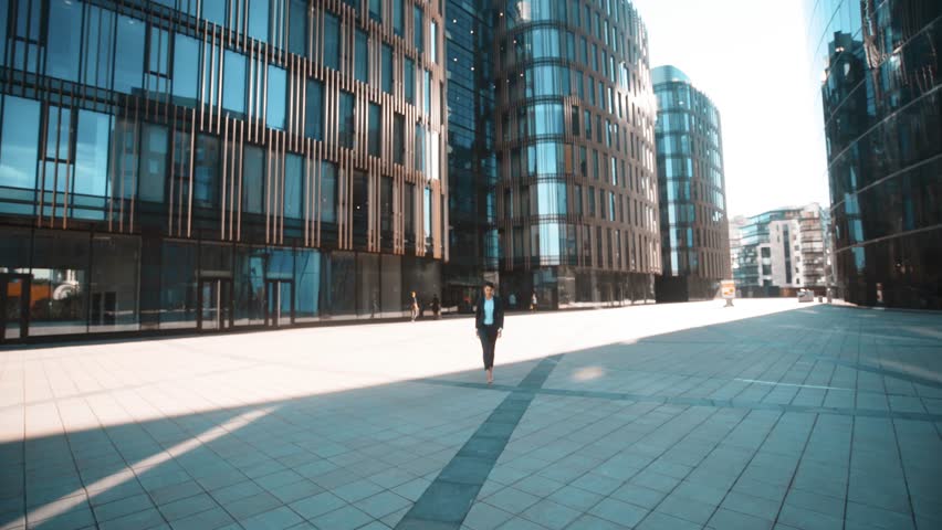 Young successful sexy attractive businesswoman in deal formal suit comes to You and shake your hand. Pomade, brownhair, lady. Teal and orange wide shot. Sunrise. Glass Business centre district