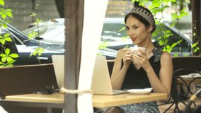 Happy successful girl working on laptop outdoors in cafe drink coffee, selective focus