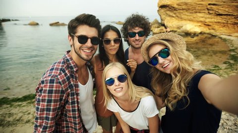 Funny friends in sunglasses taking selfies.