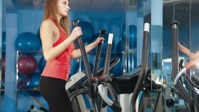 Young Girl Exercising  On Cross Trainer At The Gym