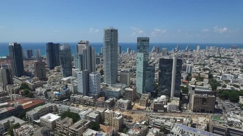 Aerial view of tall commercial buildings with the city skyline and the sea in the background 
Epic shot of Rothschild Blvd. in Tel Aviv Israel the river, ending at city skyline
Amazing aerial shot!