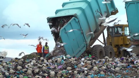 truck offloading waste into a huge landfill