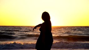 relaxing woman in a sunset at a beach. 4K Video footage clip.