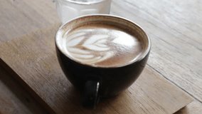 Woman enjoying hot coffee latte in the local shop