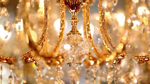 A crystal chandelier with crystals shimmers with bright lights and rotates. The ceiling light rotates and is brightly reflected in the mirror. Volumetric golden lamp with crystals rotates smoothly.