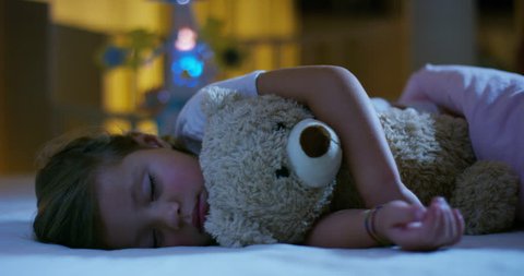 baby rests quietly in bed hugging a teddy bear toy, concept of peaceful dreams and homes without noise, happy children and mom and dad happy.
happiness in sleep, children without coughing.