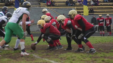 KYIV, UKRAINE - OCTOBER 18, 2015: Teams playing American football. Active attack on gridiron field to tackle ball carrier, important football match