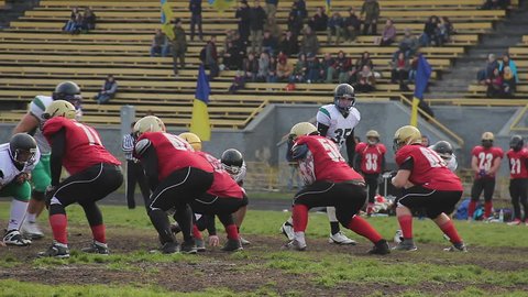 Active football players fighting for ball on field, competing to win match