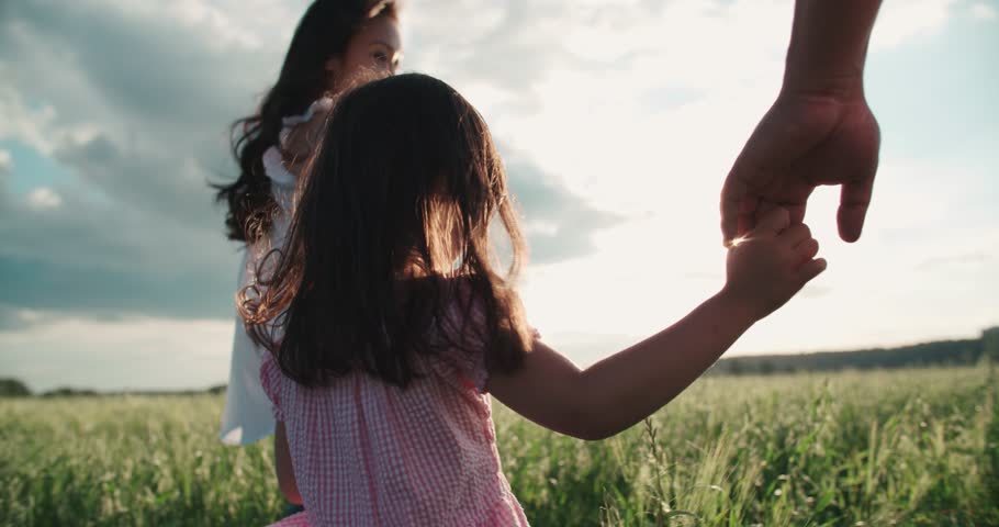 little Asian girl walking on the green field with their parents, holding hands, slow motion Royalty-Free Stock Footage #20643229