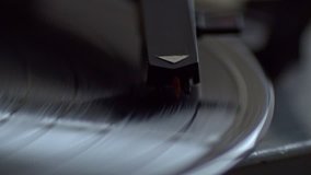 Low angle view of old fashioned turntable playing a track from black vinyl.