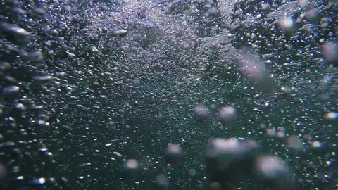 Man drowning in the sea, hand asking for help sticking out of cold water with air bubbles, pov shot