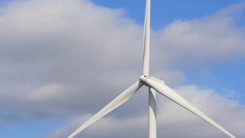 Rotating wind turbine producing alternative energy on a sky background