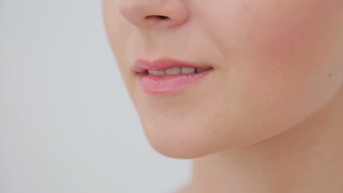 Close up of young woman's lips. White background. Beauty, fashion and make up concept