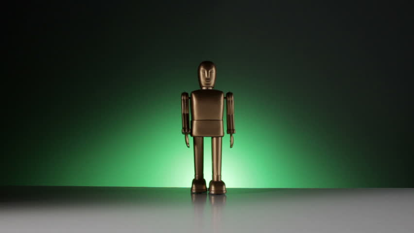 A gold colored robot walks toward the camera