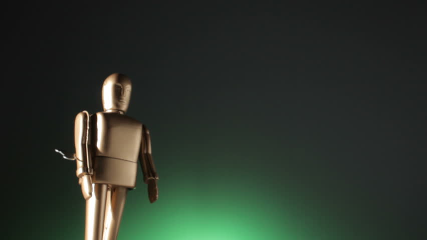 Close up of a robot walking toward the camera with a wind up key turning