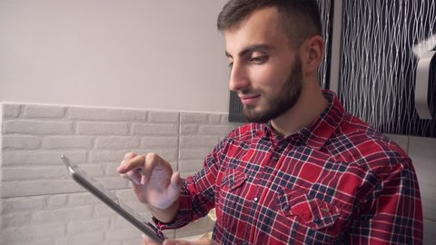 Attractive Young Man Use Tablet in Kitchen