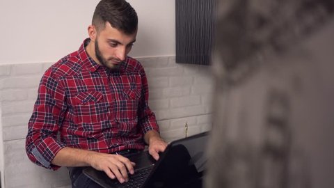 Attractive Young Man Work on Laptop in Kitchen