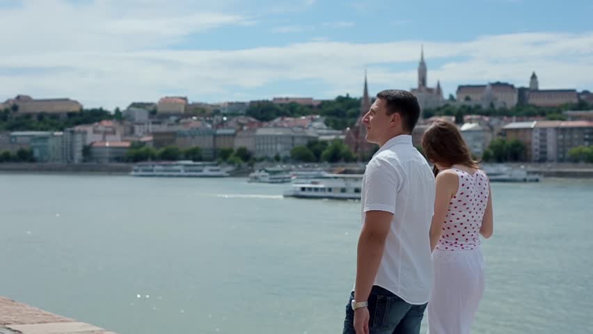 Man and a Woman Walk Along the Waterfront.