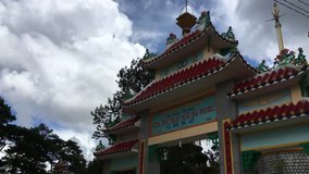 Cao Dai Temple in Trai Mat near Dalat, Lam Dong Province, Vietnam. General view of asian arch with three rings, column with rooster and main building with tower. 4k video (ultra-high definition, UHD)