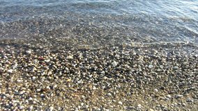 Sea waves washes pebble beach
