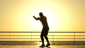 Silhouette of a confident muscular african american young man athlete training outdoors