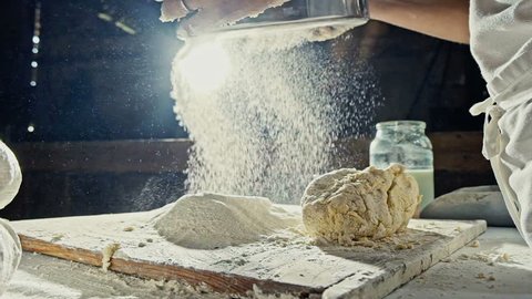 Mans hands sifting flour through a sieve for baking