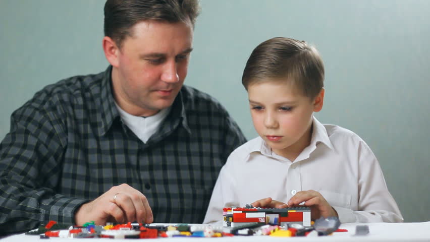 father and son playing with toys