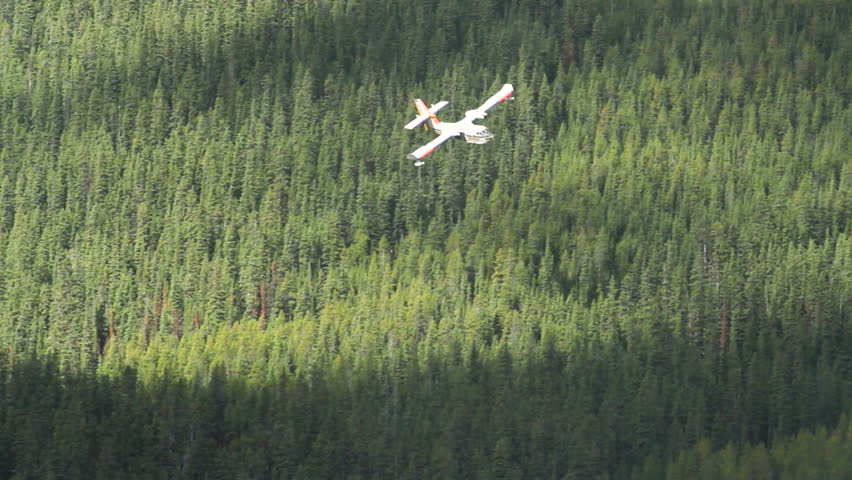 Forestry Service water bomber spraying a fire guard area