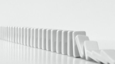 DOMINO EFFECT - white dominoes fall in chain reaction
B/W with plenty room for copy