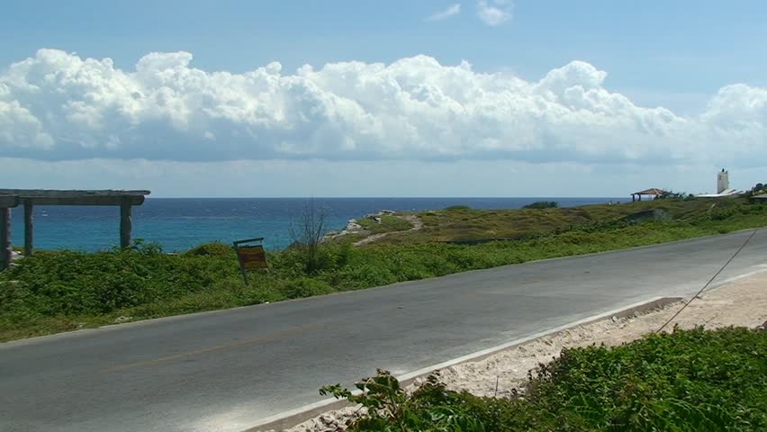 Police patrol and tourist Golf Car drive the Tropic Sea Shore Road. Golf car is probaly lookong for their golf ball. Mexico.