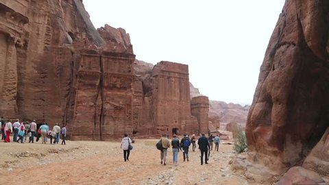 Petra, Jordan - October 26, 2015: Tourists walking along the canyon in Petra. View of the city of Petra in Jordan. Tourist route of Petra in Jordan. Carved city in the mountains.