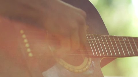 Slow motion. Close-up of guitar playing. Guitarist hits the strings of the guitar. Skill. Playing a musical instrument. Stringed Musical Instruments. Black guitar with abrasions. Old Guitar.