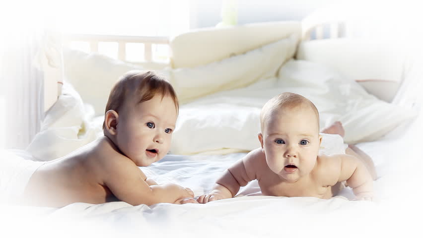 Two happiness babies funning on the bed 